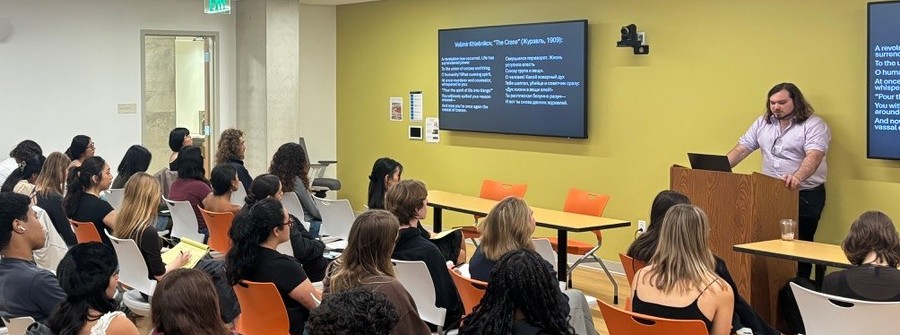 4 of 4, One person giving a lecture in a classroom to many people.
